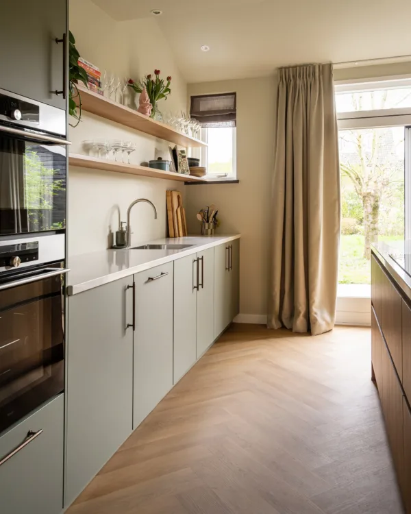 Keuken met luxe afwerking, lichte kleuren en visgraatvloer als stijlvolle basis.