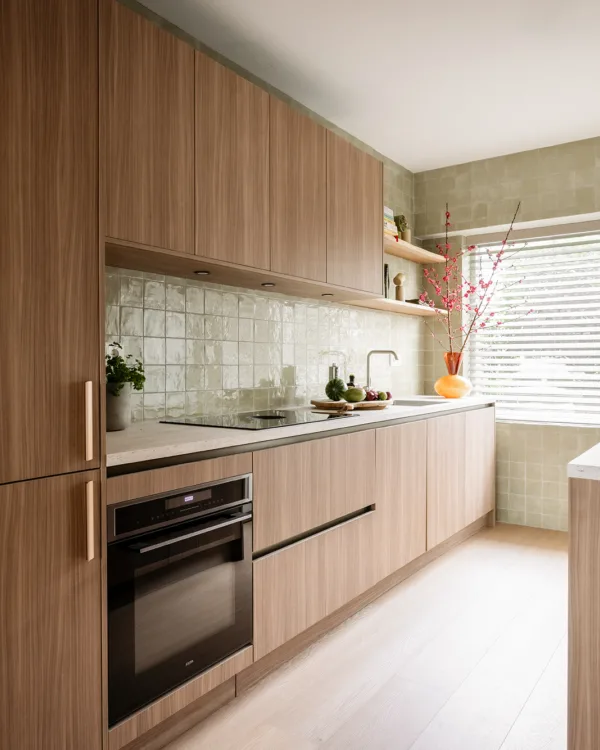 Moderne keuken met houtlook keukenkasten en lichtgroene muurtegels