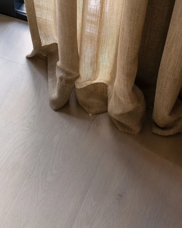 Close-up van COREtec® PVC vloer en Inspire inbetween gordijnen in de woonkamer