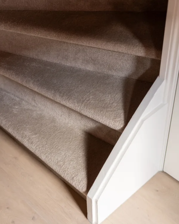 Trapdetail met zachte, luxe tapijtbekleding in zandtint