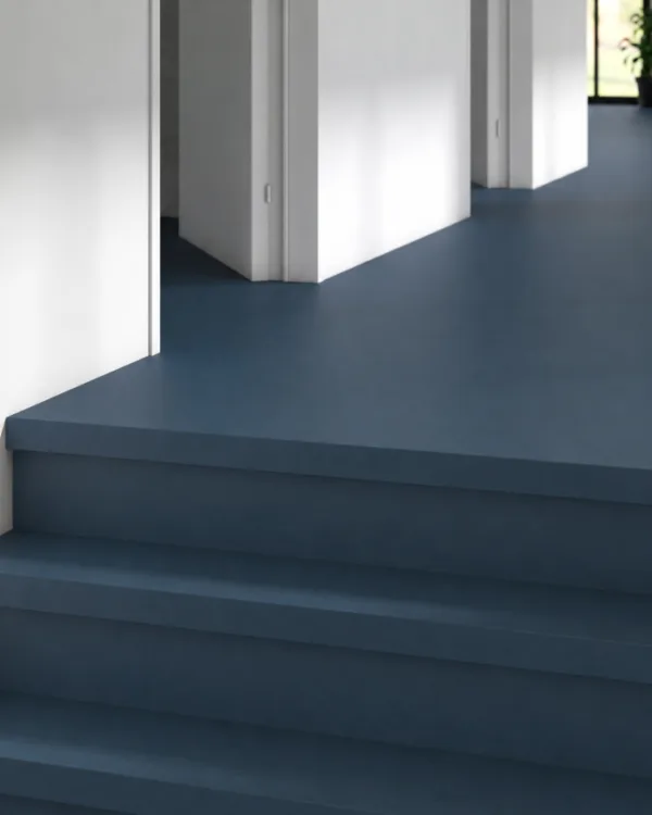 Donkerblauw marmoleum doorgelegd op de vloer en traptreden.