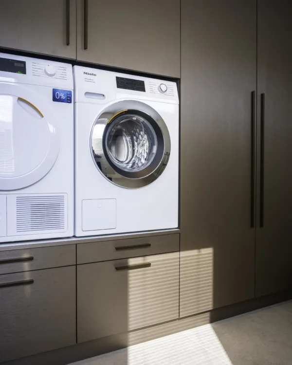 Bruine wasmachinekast met draaideuren en langwerpige grepen