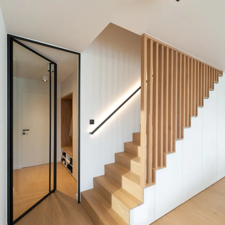 Een lichte trap met ledgrip en stalen deur naar de hal