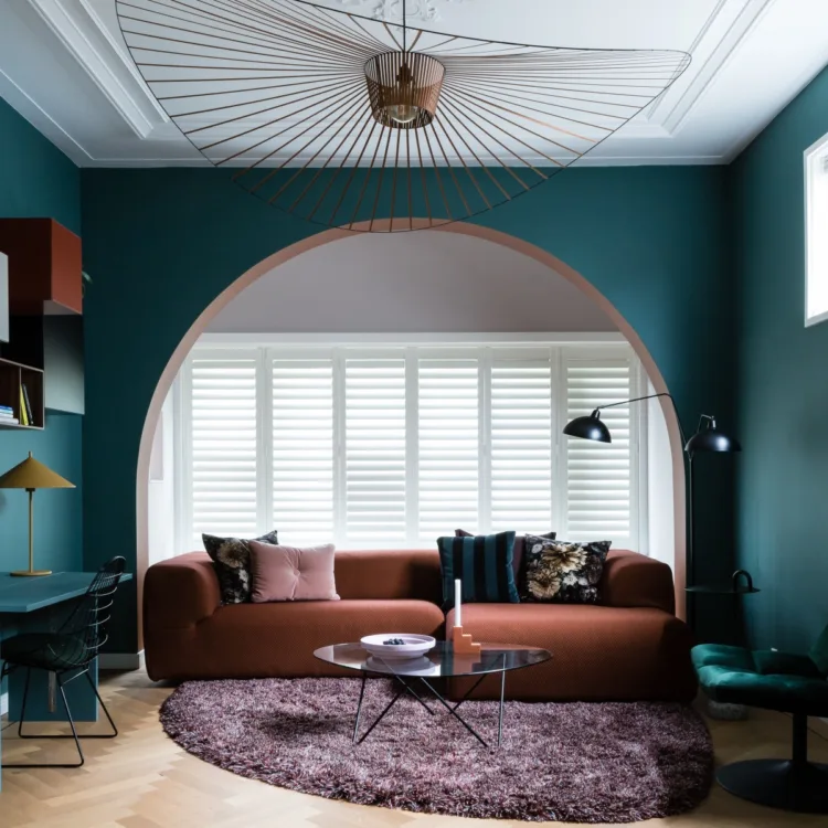 Hotel chique interieur met luxe bankstel en witte shutters als raamdecoratie.
