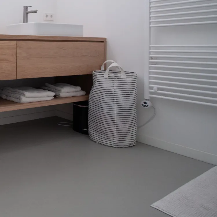 Gietvloer naadloos in badkamer met houten meubelen