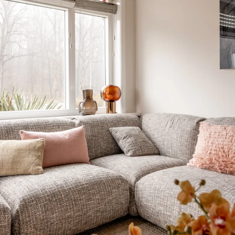Sfeerfoto van een basic naturel woonkamer met witte horizontale jaloezieën