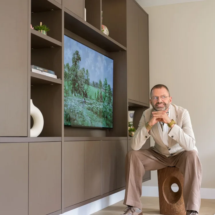 Frans Uyterlinde naast een Cinewall kast in donkere tint