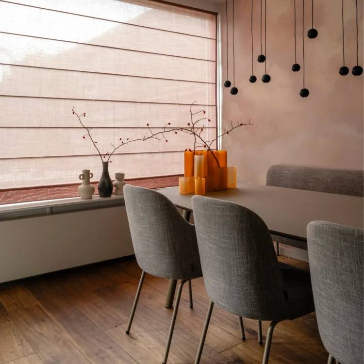 Warm kleurrijk interieur met oude roze vouwgordijnen in eethoek met wolkerig behang