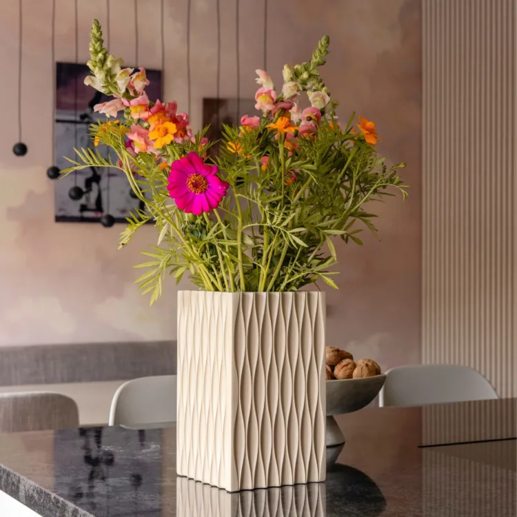 Sfeerfoto van vaas met kleurrijke bloemen in keuken