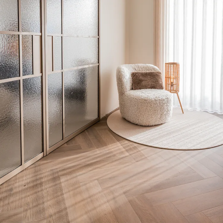 Lichte zithoek met stalen deuren, visgraat vloer, beige vloerkleed en inbetweens