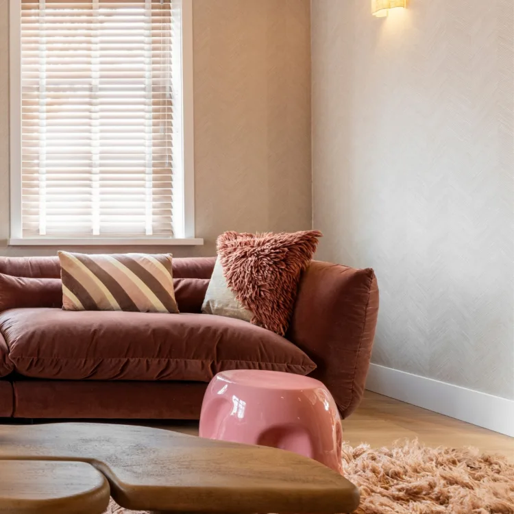 Warmkleurijke woonkamer met fluffy vloerkleed en houten jaloezieën