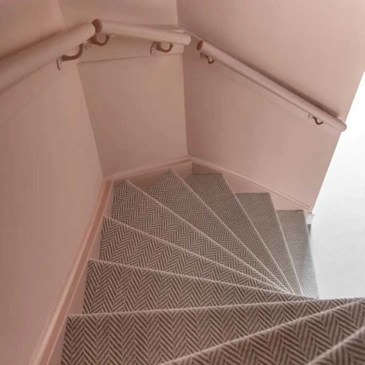trap met trapbekleding en roze geverfde muren