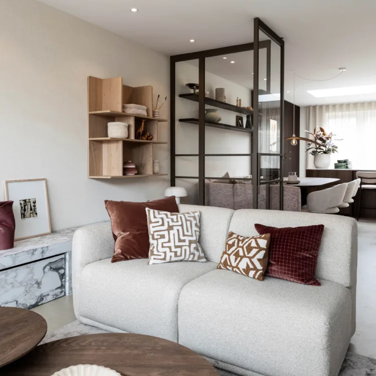 woonkamer met zithoek en stalen deur met lichte kleuren op de muur