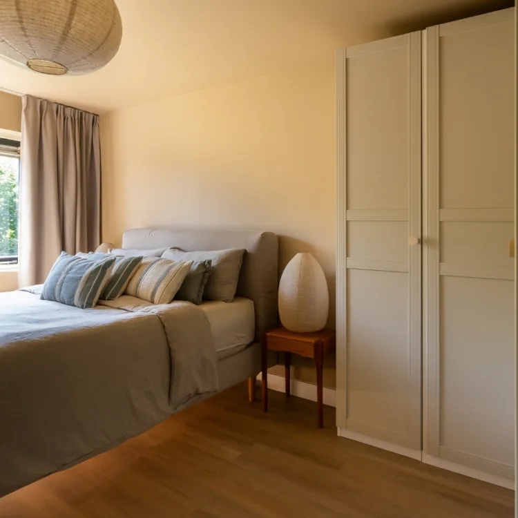 pvc-vloer licht eiken lange plank en beige bruine overgordijnen in slaapkamer