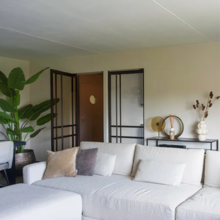 hotel chic woonkamer met bronze stalen deuren en grote grijze hoekbank