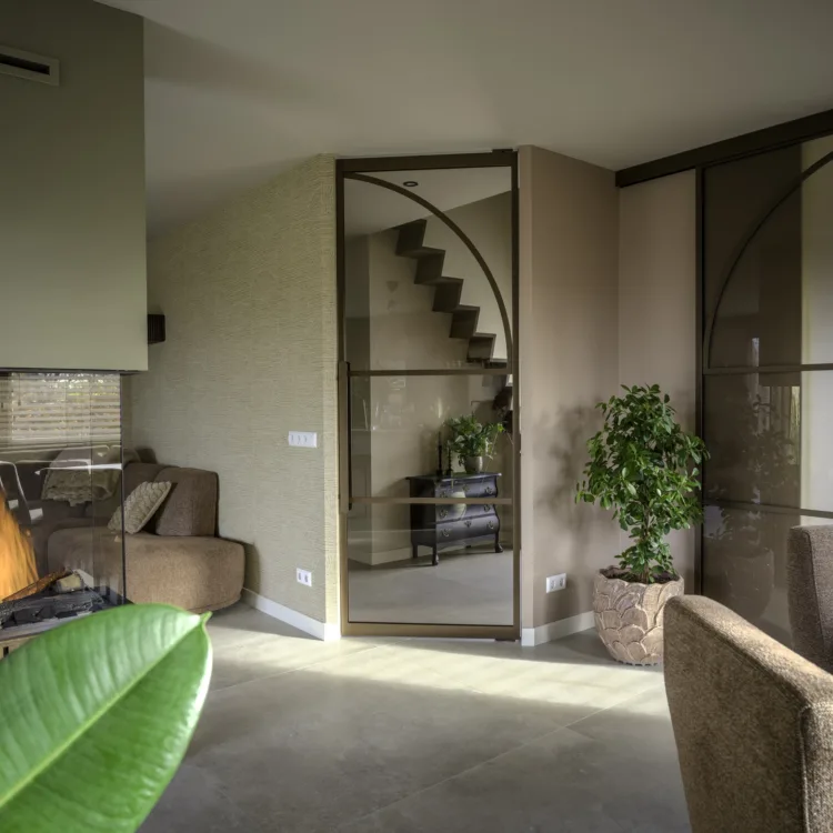 Woonkamer met lichtgrijze keramische tegels vloer en bronzen stalen deuren