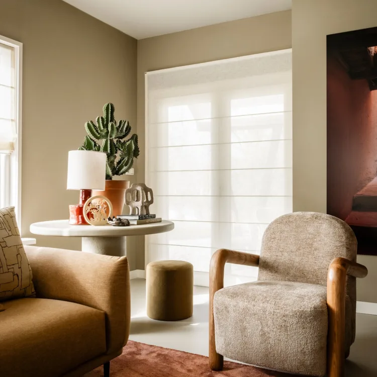 Woonkamer met luxe vouwgordijnen en warme, natuurlijke materialen voor een knusse sfeer.