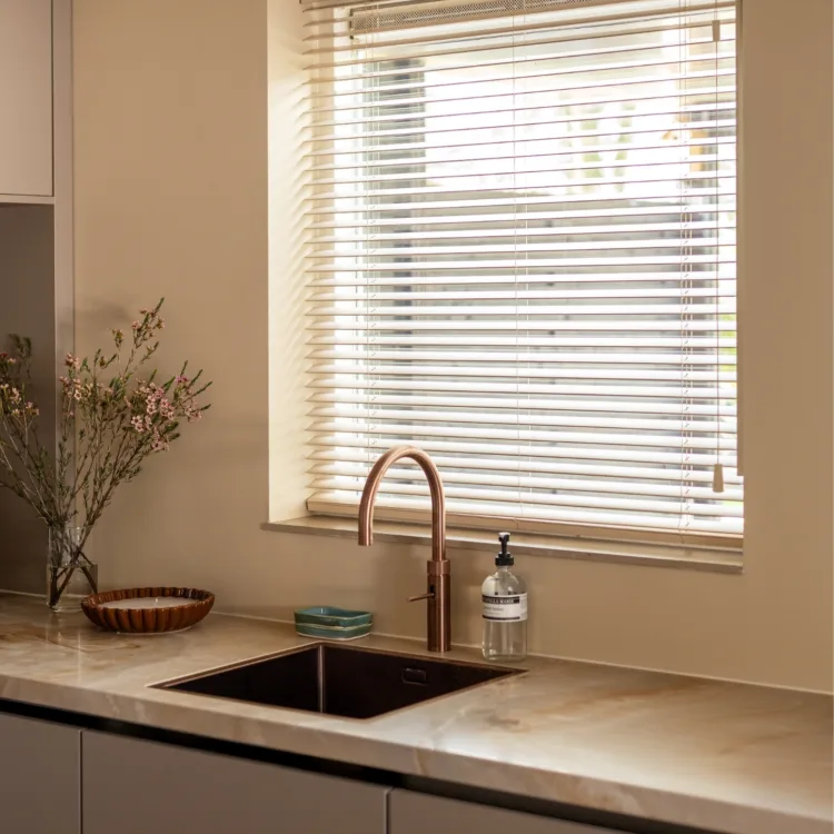 New chic keuken met beige houten jaloezieën boven wasbak