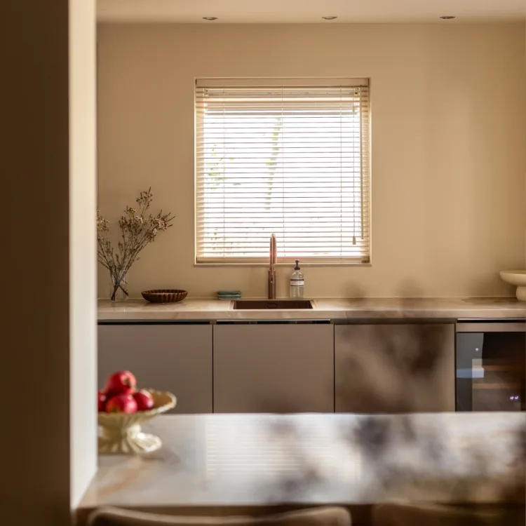 New chic keuken met beige houten jaloezieën boven wasbak