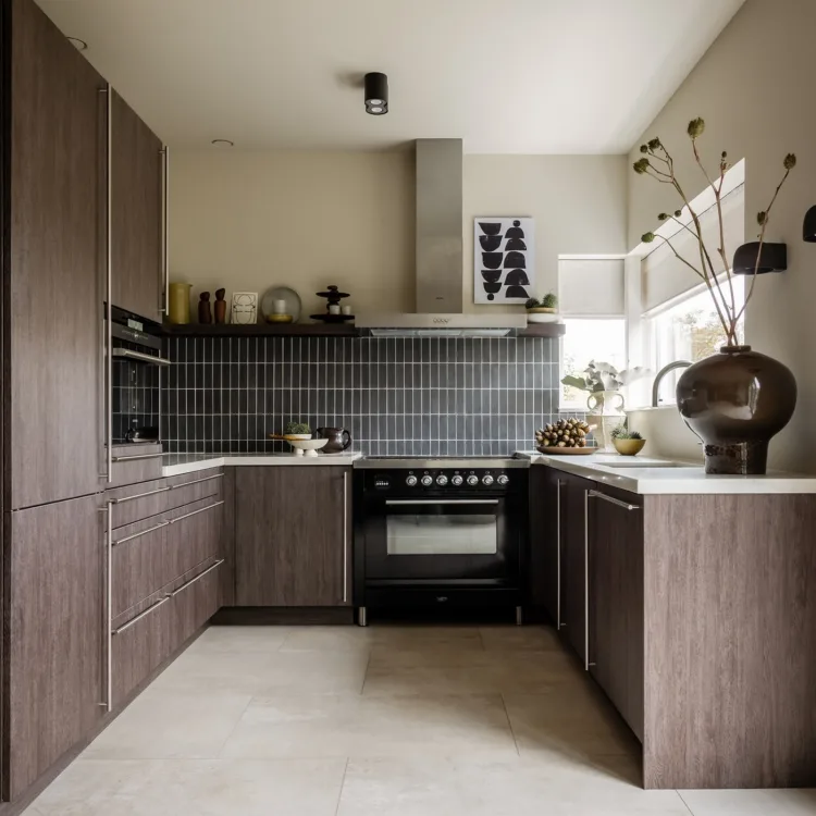 Keuken met bruine kasten, wit werkblad en lichtgrijze tegelvloer.