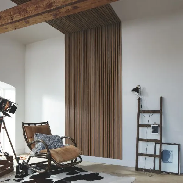 Moderne woonkamer met houten wandpanelen die naadloos doorlopen op het plafond voor een warme en luxe uitstraling.