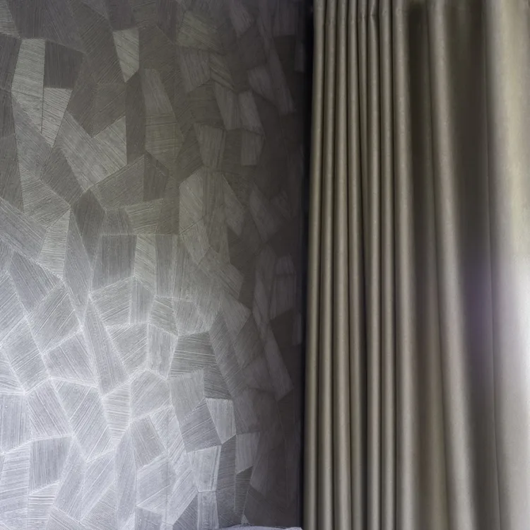 Hotel chique slaapkamerhoek met taupe verduisterende gordijnen, zacht hoofdbord en luxe structuurbehang in neutrale tinten.