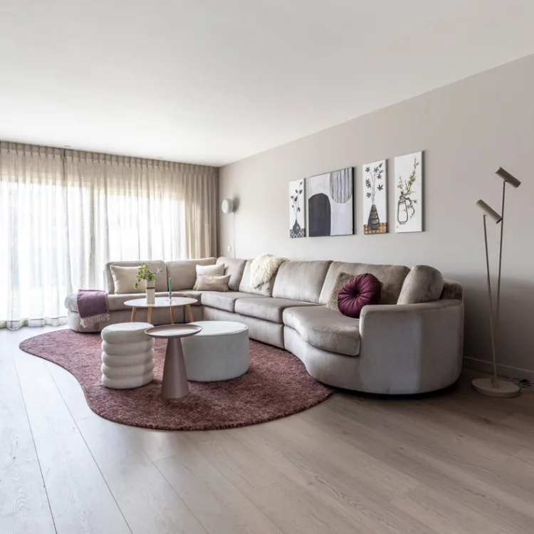 PVC-vloer met houtlook in een lichte woonkamer met een beige hoekbank en organisch vloerkleed.