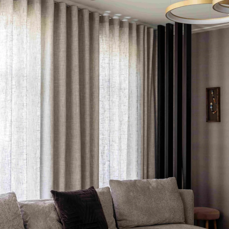 Lichtdoorlatende grijze gordijnen in een moderne woonkamer.