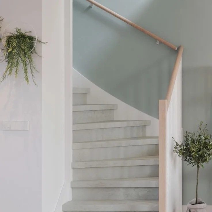 Design laminaattrap in betonlook gecombineerd met bijpassende vloer in woonkamer